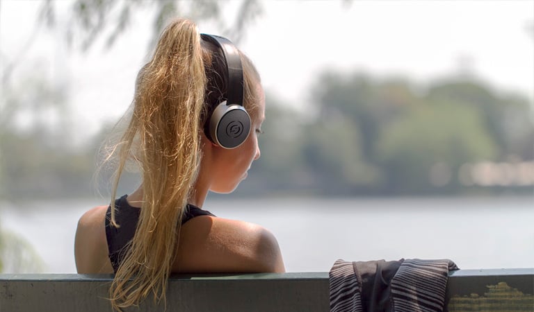 female listening outdoors with SR450 headphones